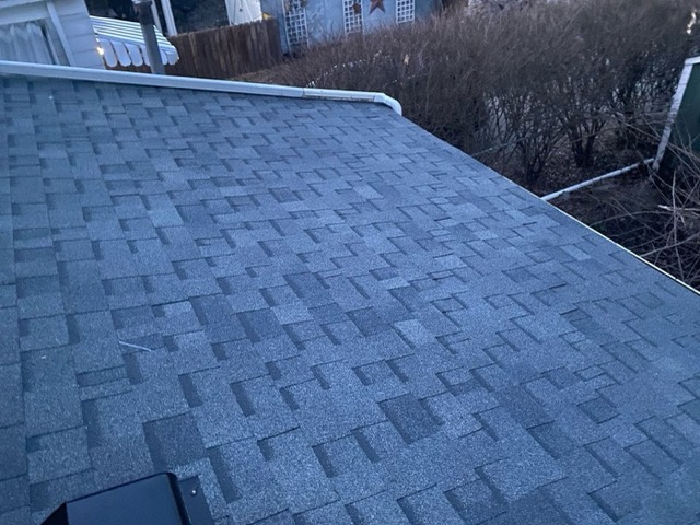 New shingles up close: A close-up of new grey architectural shingles and their even courses.