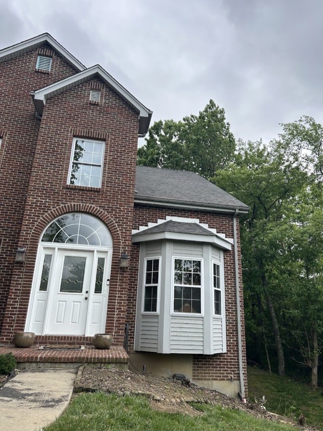 Two-storey brick home: A brick home with an arched entry window and bay window under its roof.