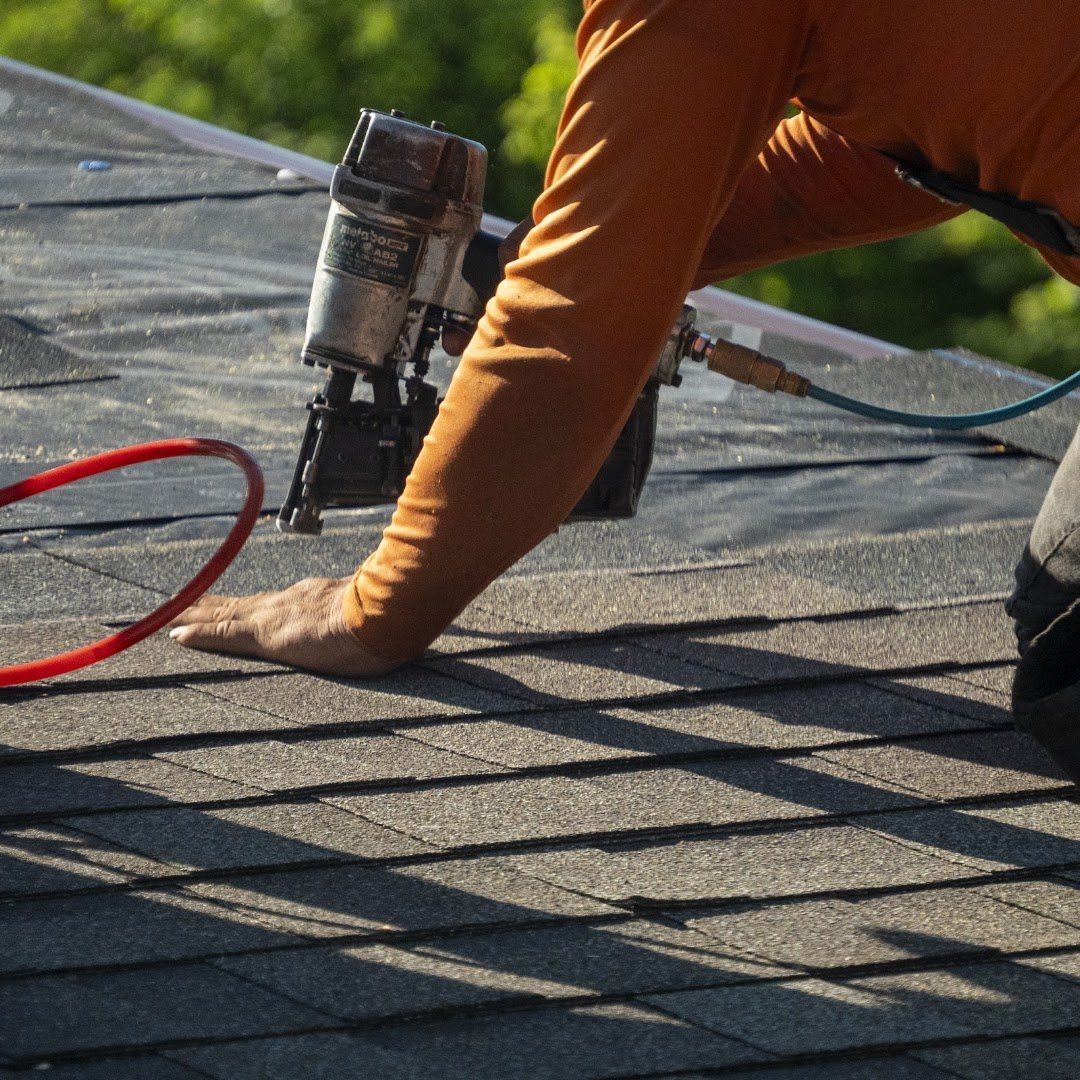 A Straight A roofer fastening new architectural shingles